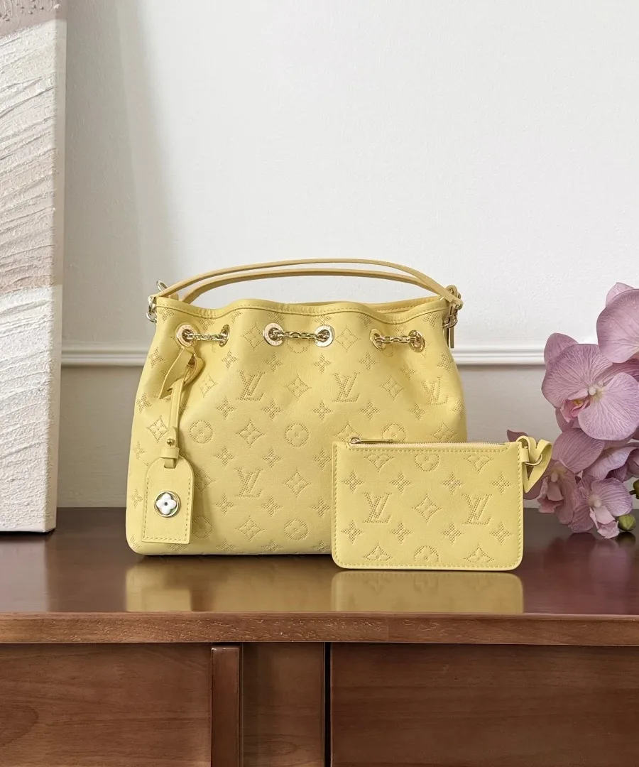 Жёлтая сумка-ведро Louis Vuitton Bella с небольшим кошельком на деревянном столе