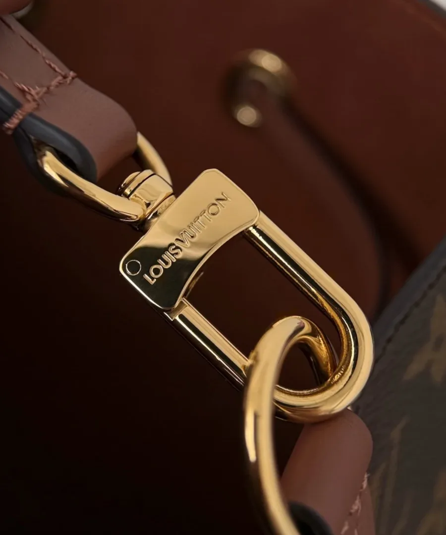 Золотистый карабин с гравировкой Louis Vuitton крупным планом