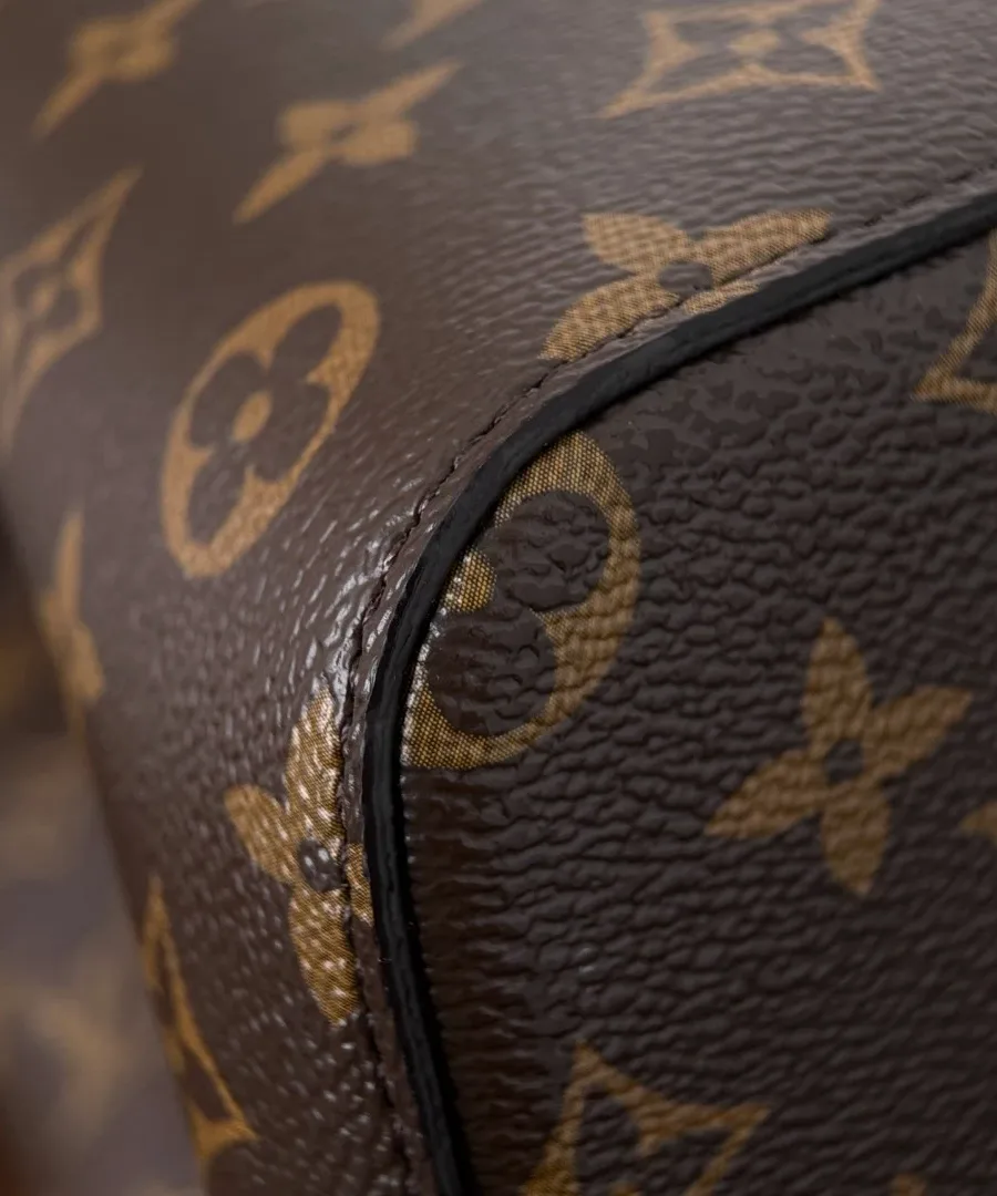 Крупный план шва на нижнем углу сумки Louis Vuitton