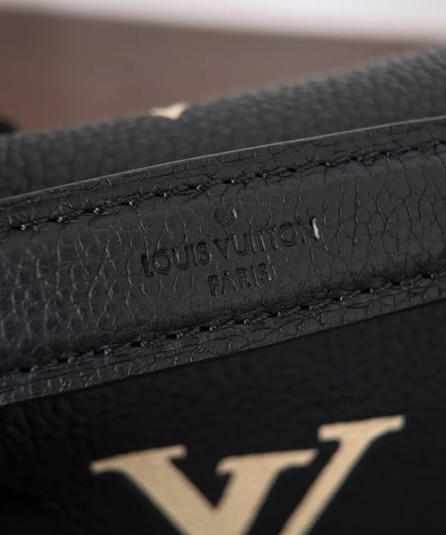 Крупный план тиснения Louis Vuitton Paris на черной коже сумки
