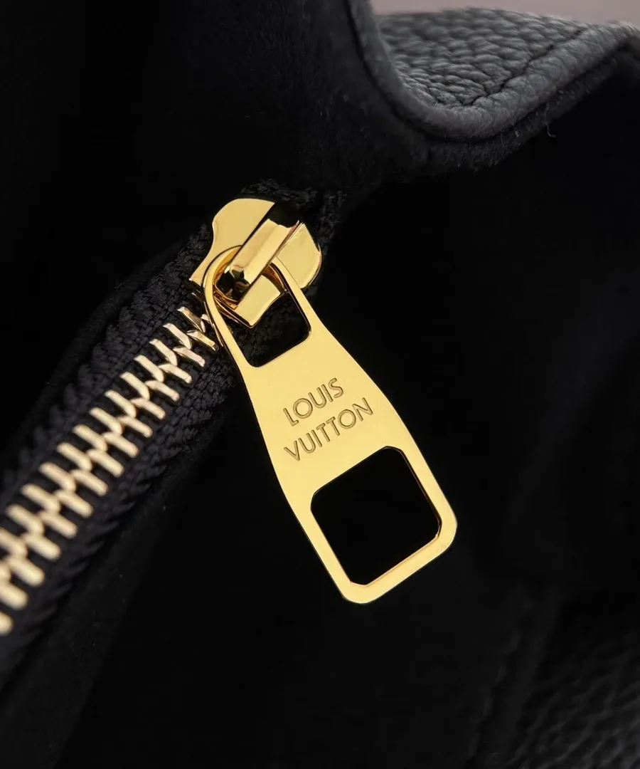 Золотистый пуллер молнии с гравировкой Louis Vuitton крупным планом