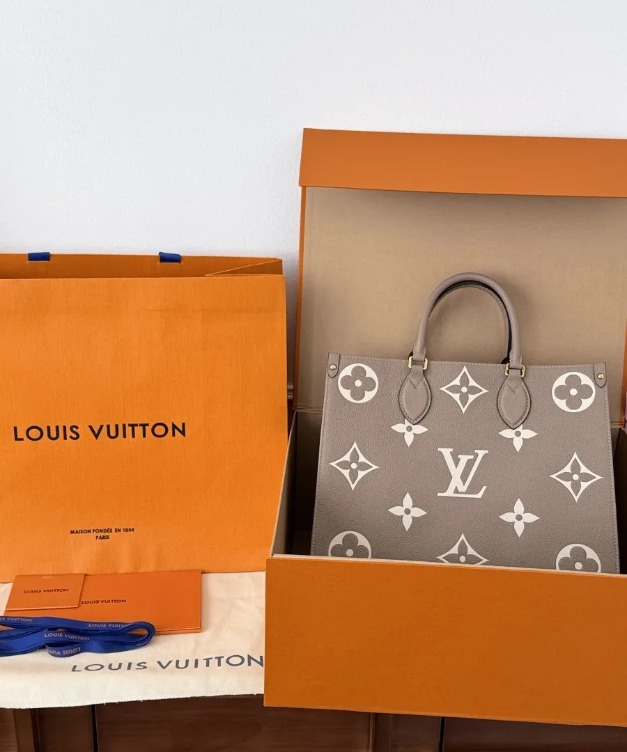 Сумка Louis Vuitton OnTheGo MM рядом с фирменной коробкой и пакетом