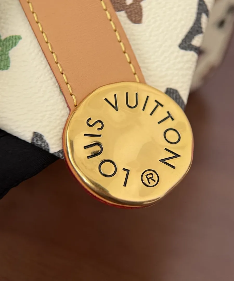 Золотистая кнопка с гравировкой Louis Vuitton на ремешке, крупный план