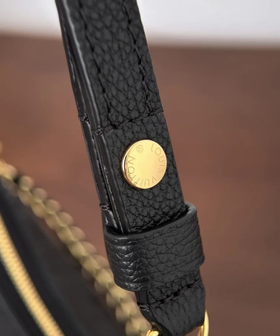 Крупный план кожаного ремня с золотистой кнопкой Louis Vuitton