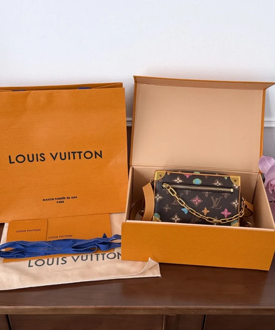 Сумка Louis Vuitton Mini Soft Trunk рядом с фирменной коробкой и пакетом