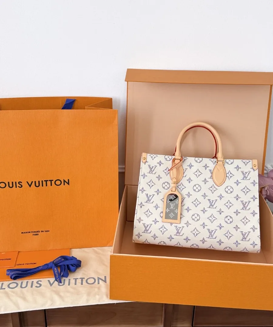 Сумка-тоут OnTheGo MM в фирменной коробке Louis Vuitton рядом с пакетом