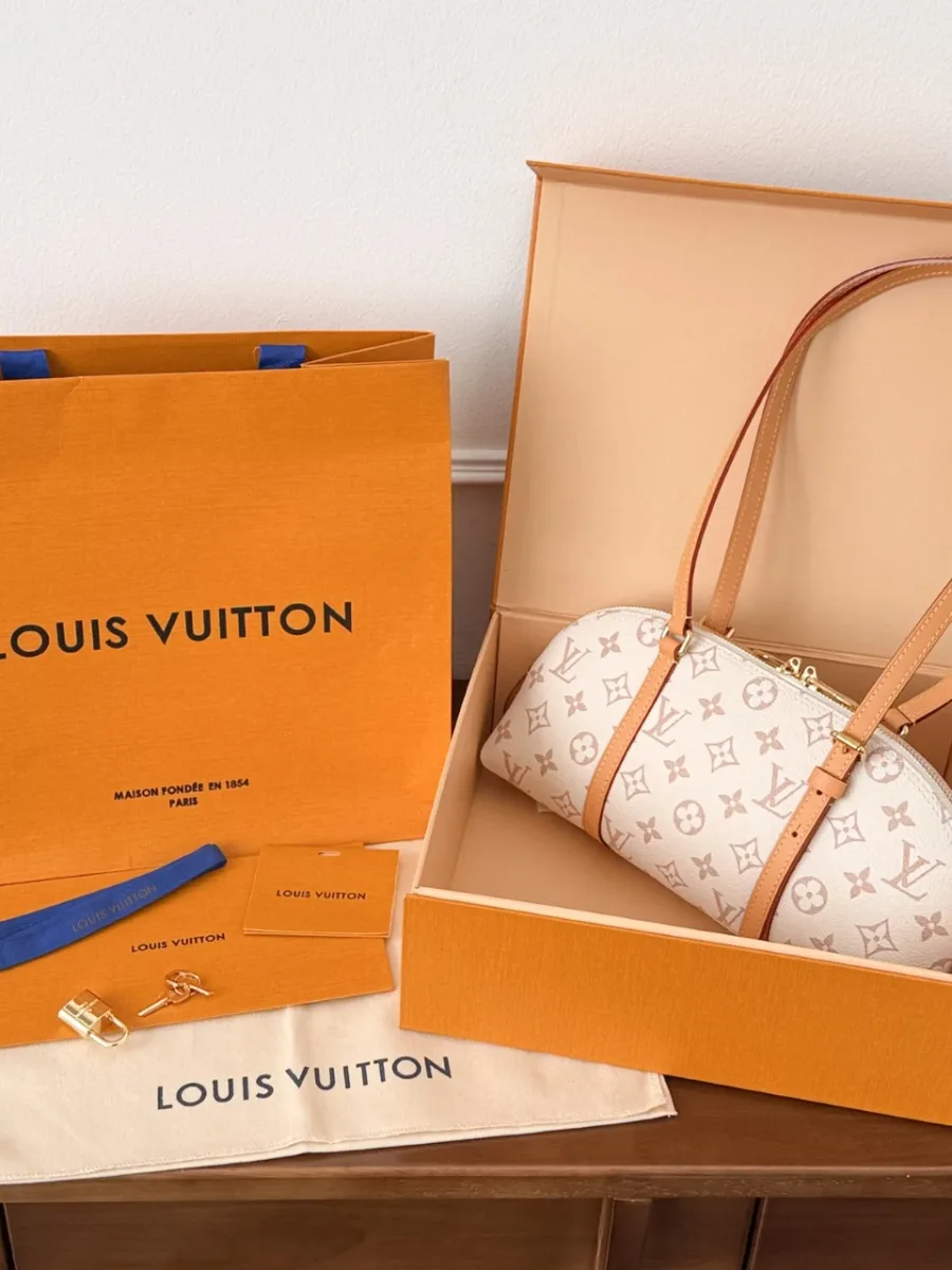 Сумка Louis Vuitton Alma Bowling рядом с фирменной коробкой и пакетом