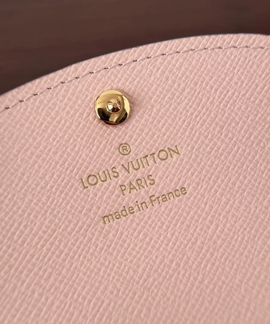 Крупный план золотистого тиснения Louis Vuitton Paris на розовой коже