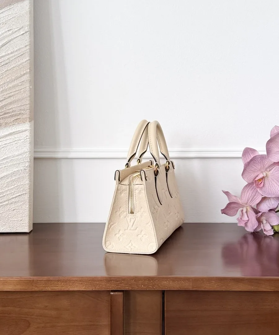 Белая сумка Louis Vuitton OnTheGo East West, вид сбоку