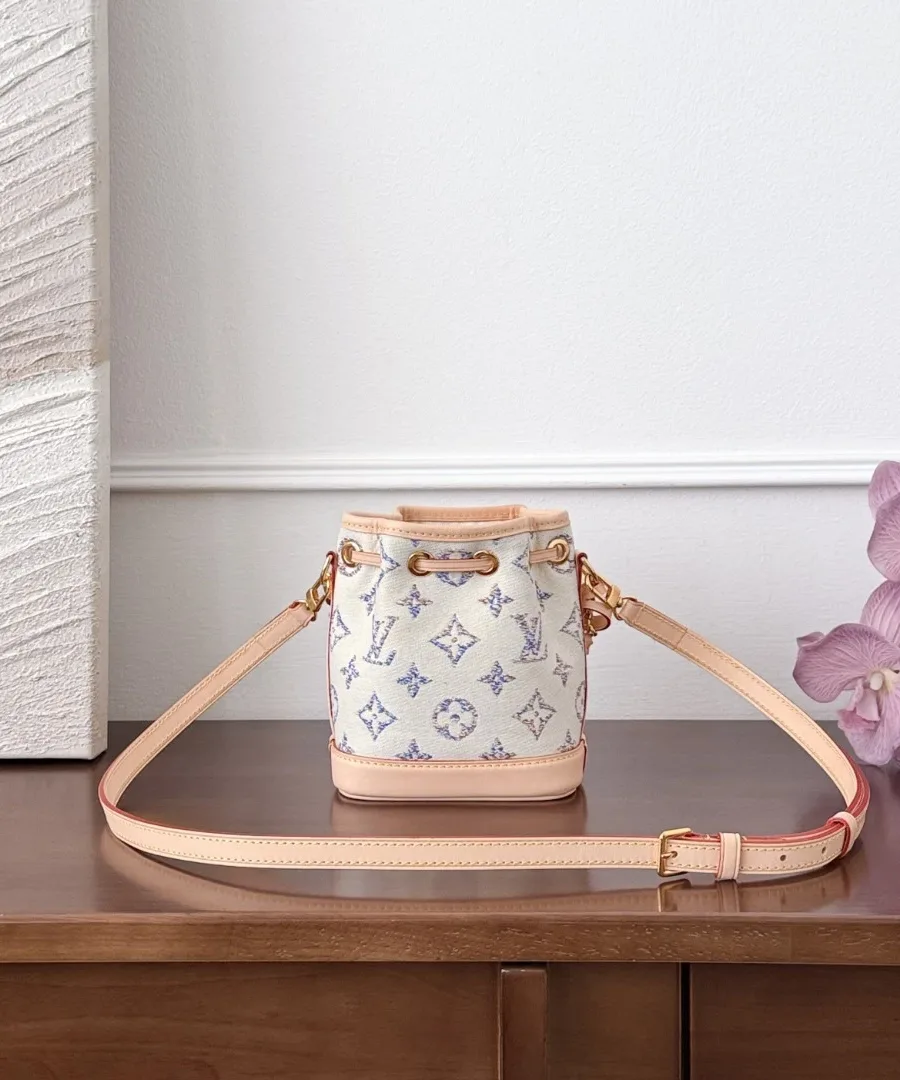 Белая мини-сумка-ведро Louis Vuitton с цветочным принтом, вид спереди с кожаным ремнем