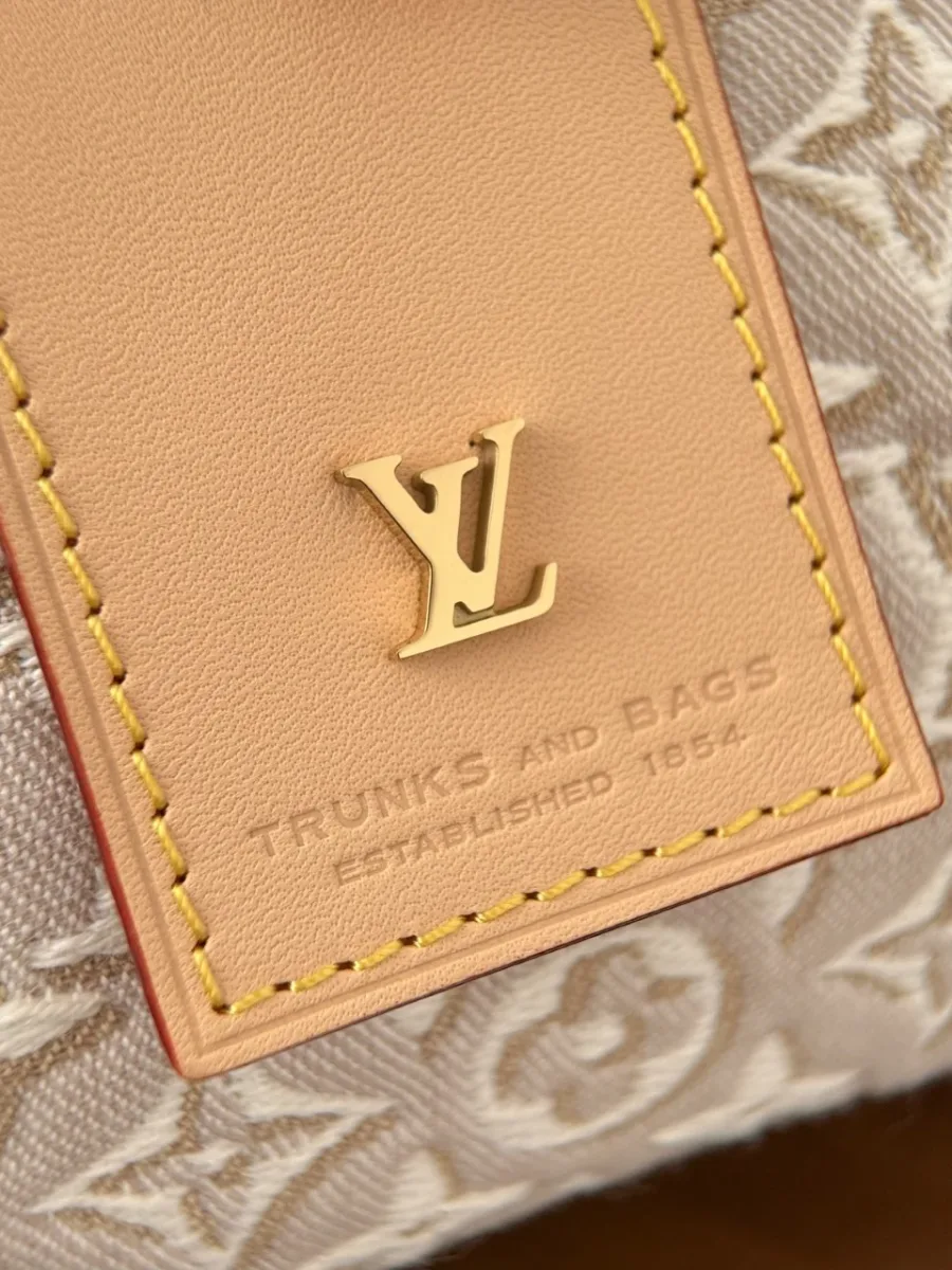 Крупный план кожаной бирки с золотистым логотипом LV и тиснением Trunks and Bags