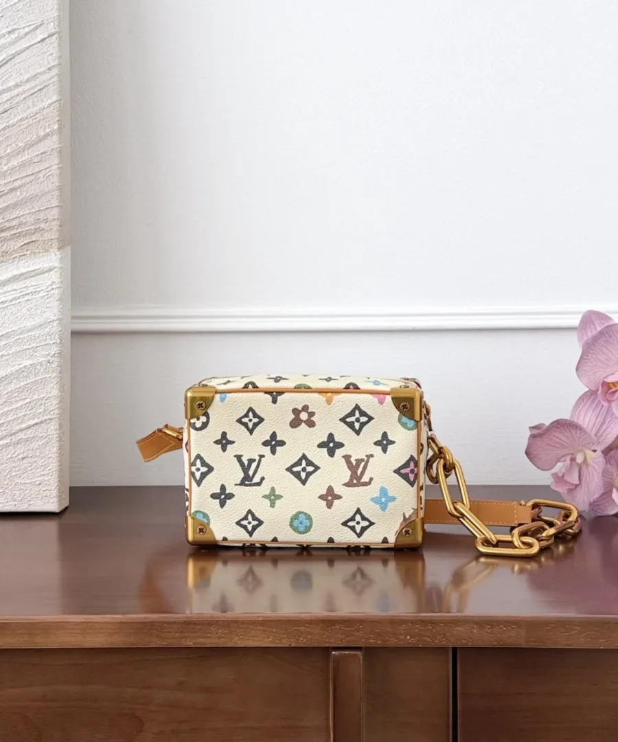 Разноцветная сумка Louis Vuitton Mini Soft Trunk, вид сзади на фоне цветка