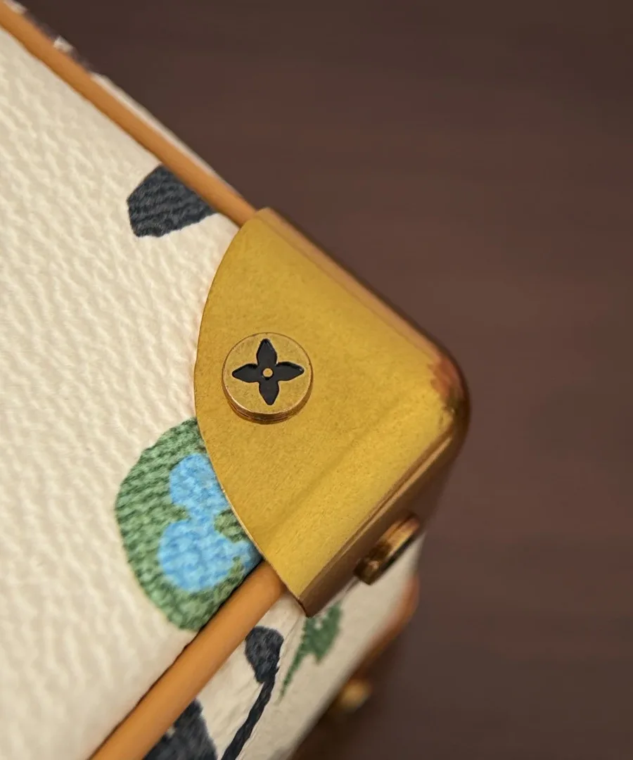 Золотистый металлический уголок сумки Louis Vuitton с гравировкой