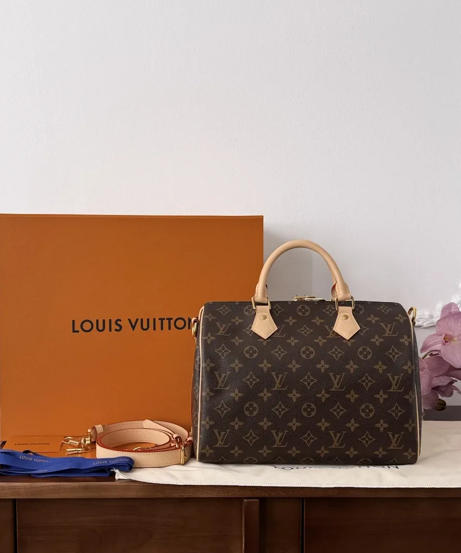 Сумка Louis Vuitton Speedy 30 рядом с фирменной оранжевой коробкой и пыльником