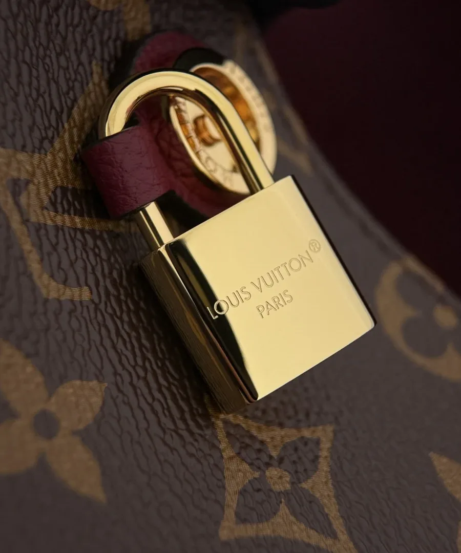 Крупный план золотистого замка-падлока с гравировкой Louis Vuitton Paris