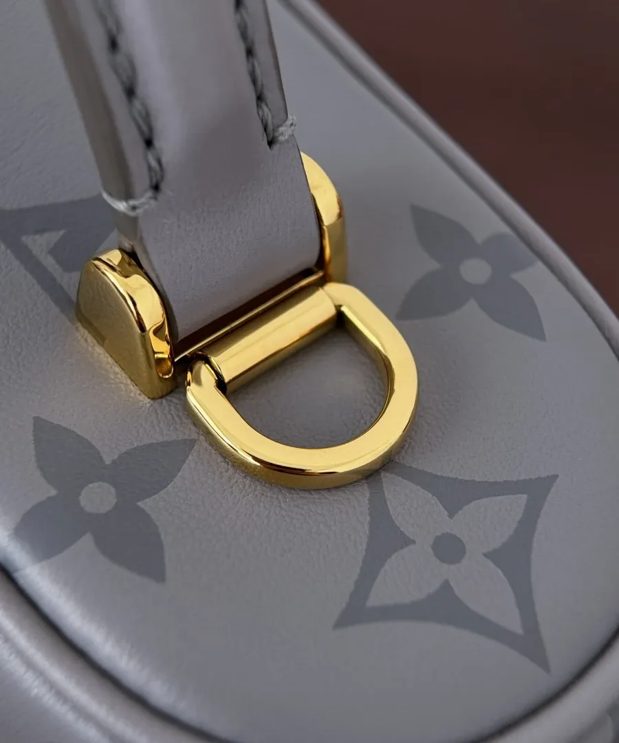 Золотистое крепление ручки серой сумки Louis Vuitton