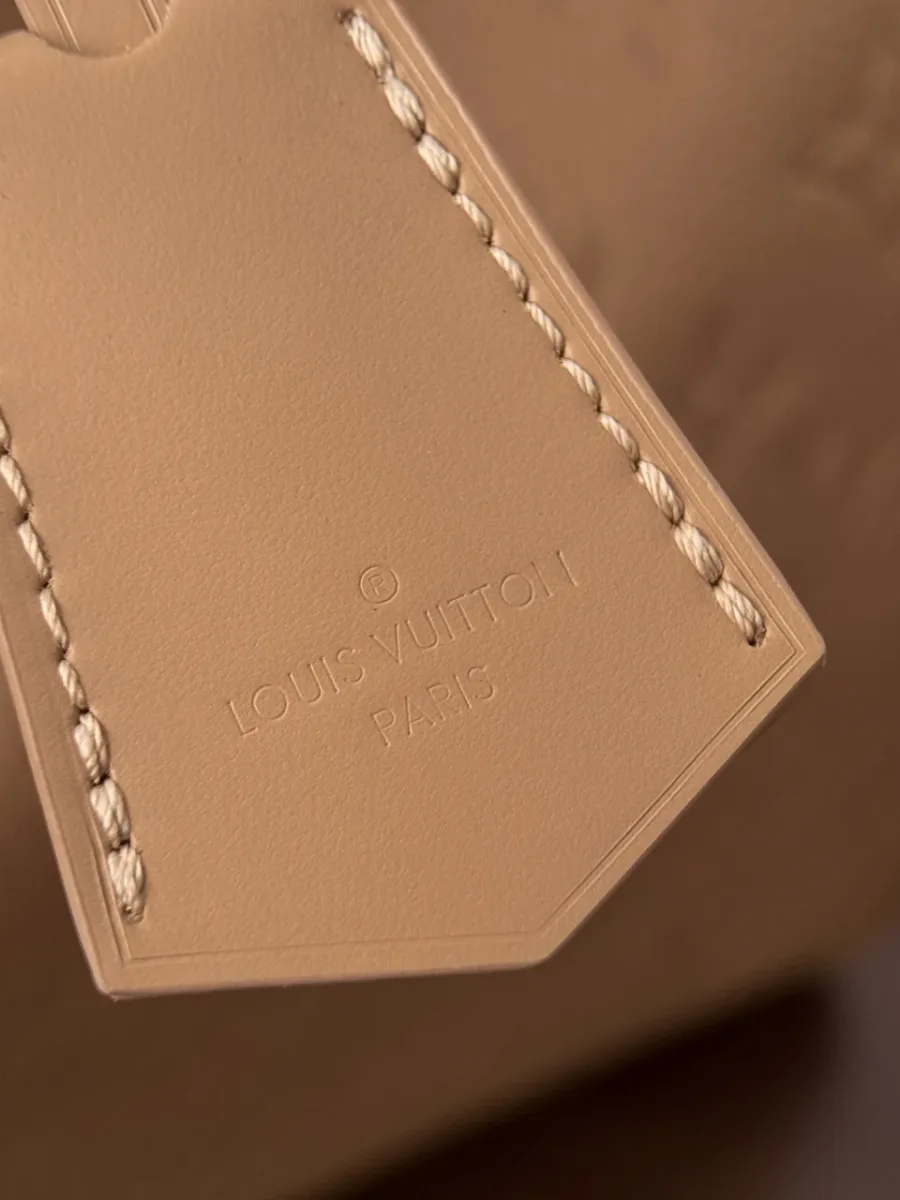 Крупный план кожаной багажной бирки с тиснением Louis Vuitton
