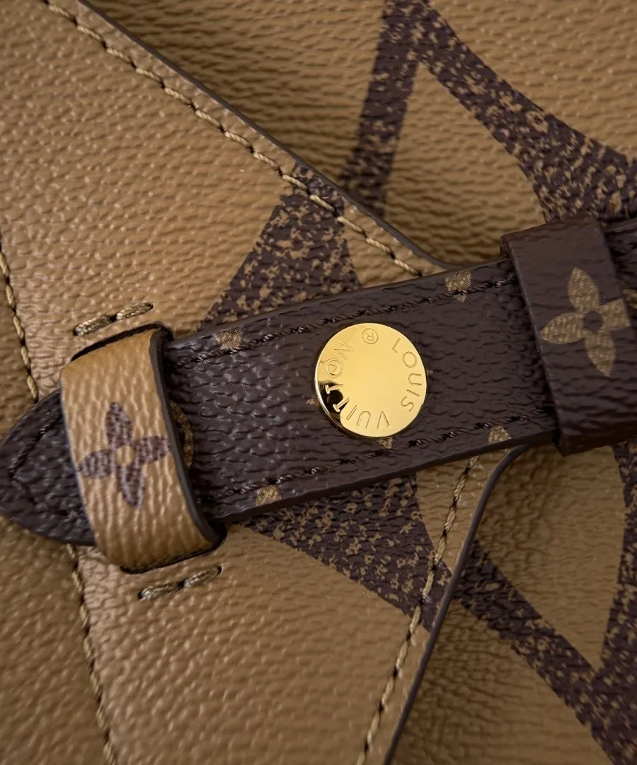 Деталь кожаного ремешка с золотистой кнопкой на сумке Louis Vuitton Onthego