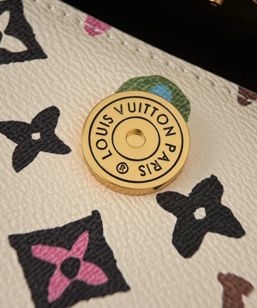 Крупный план круглой золотистой кнопки с гравировкой Louis Vuitton Paris