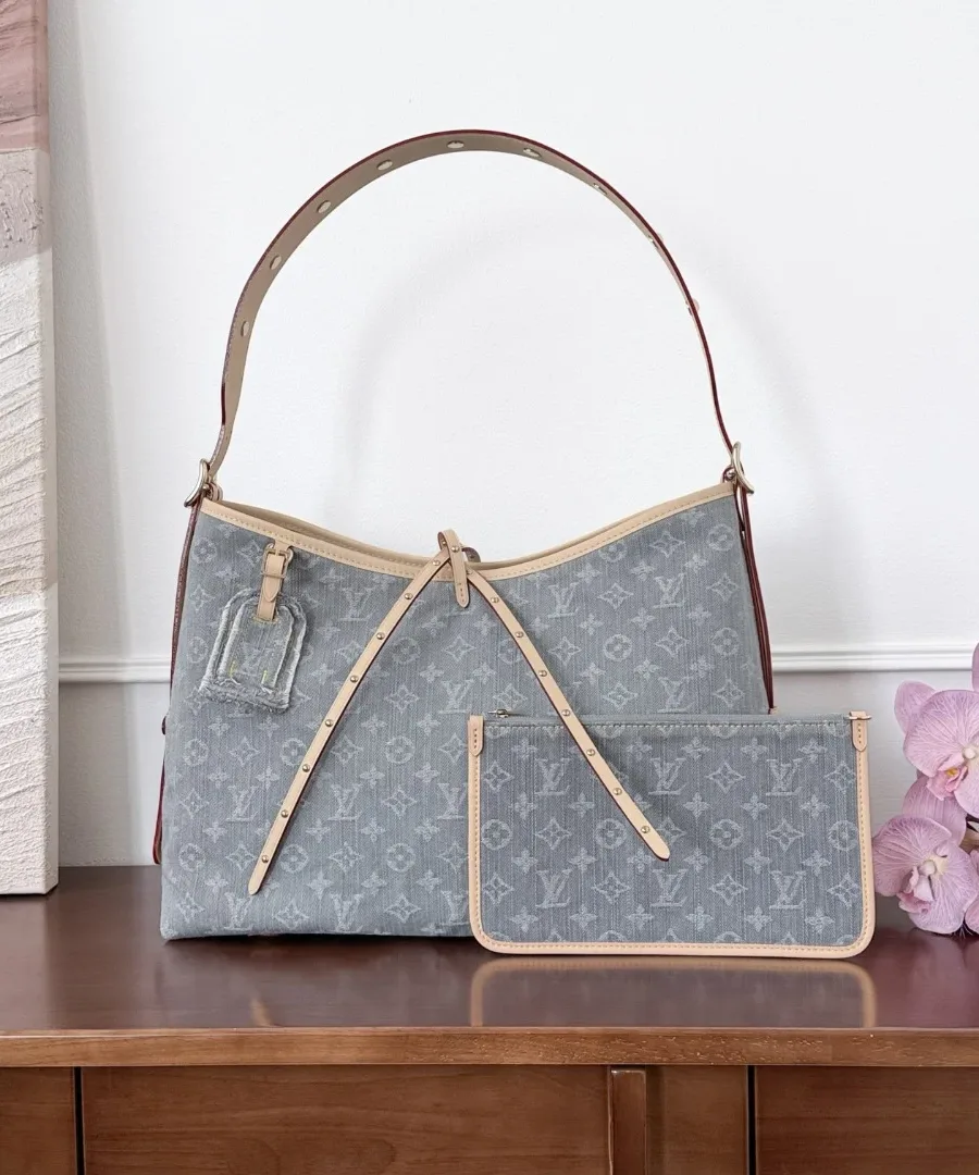 Серая джинсовая сумка Louis Vuitton CarryAll MM с кошельком на деревянном столе, вид спереди