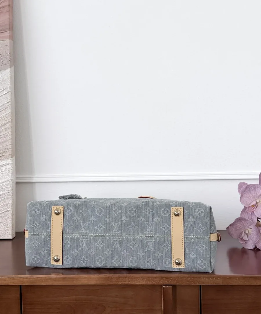 Дно серой джинсовой сумки Louis Vuitton CarryAll с кожаными ножками-полосками