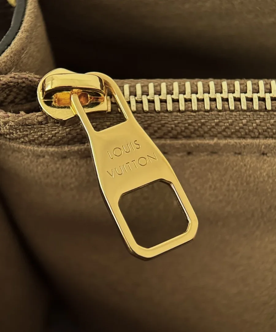 Золотистый металлический пуллер молнии с гравировкой Louis Vuitton.