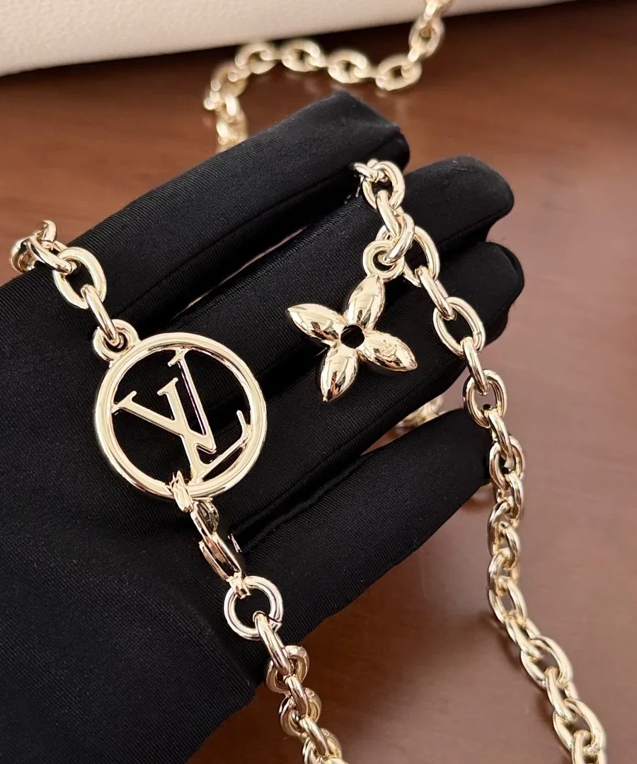 Золотистая цепочка с круглым логотипом LV и цветком Monogram в руке
