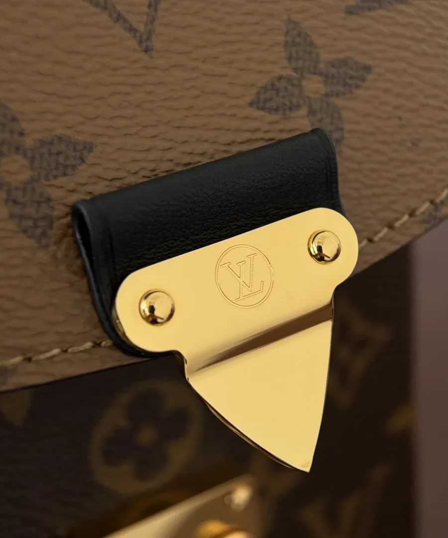 Крупный план золотистого замка S-lock на клапане сумки Louis Vuitton Camera Box