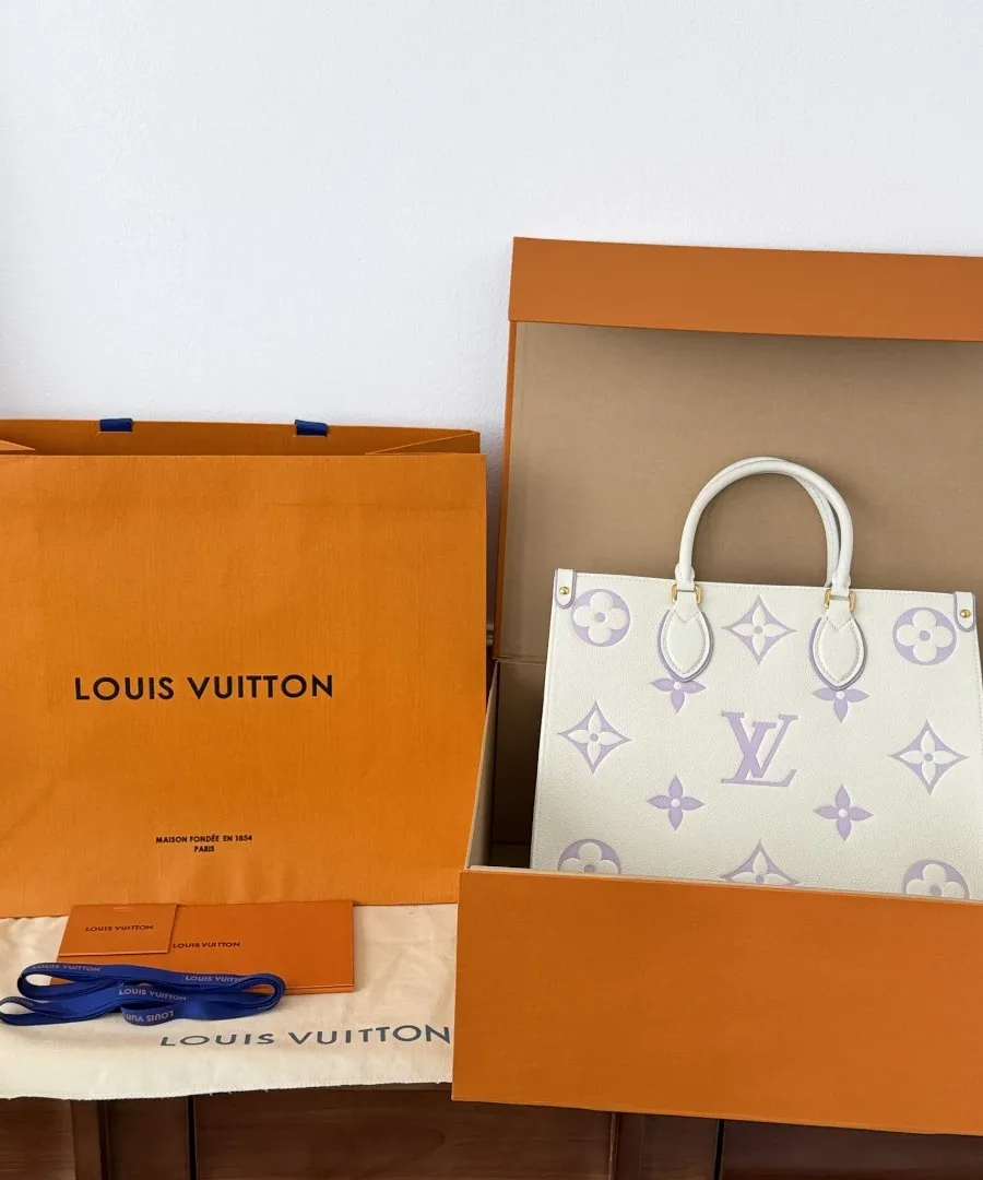 Сумка-тоут OnTheGo рядом с фирменной коробкой и пакетом Louis Vuitton