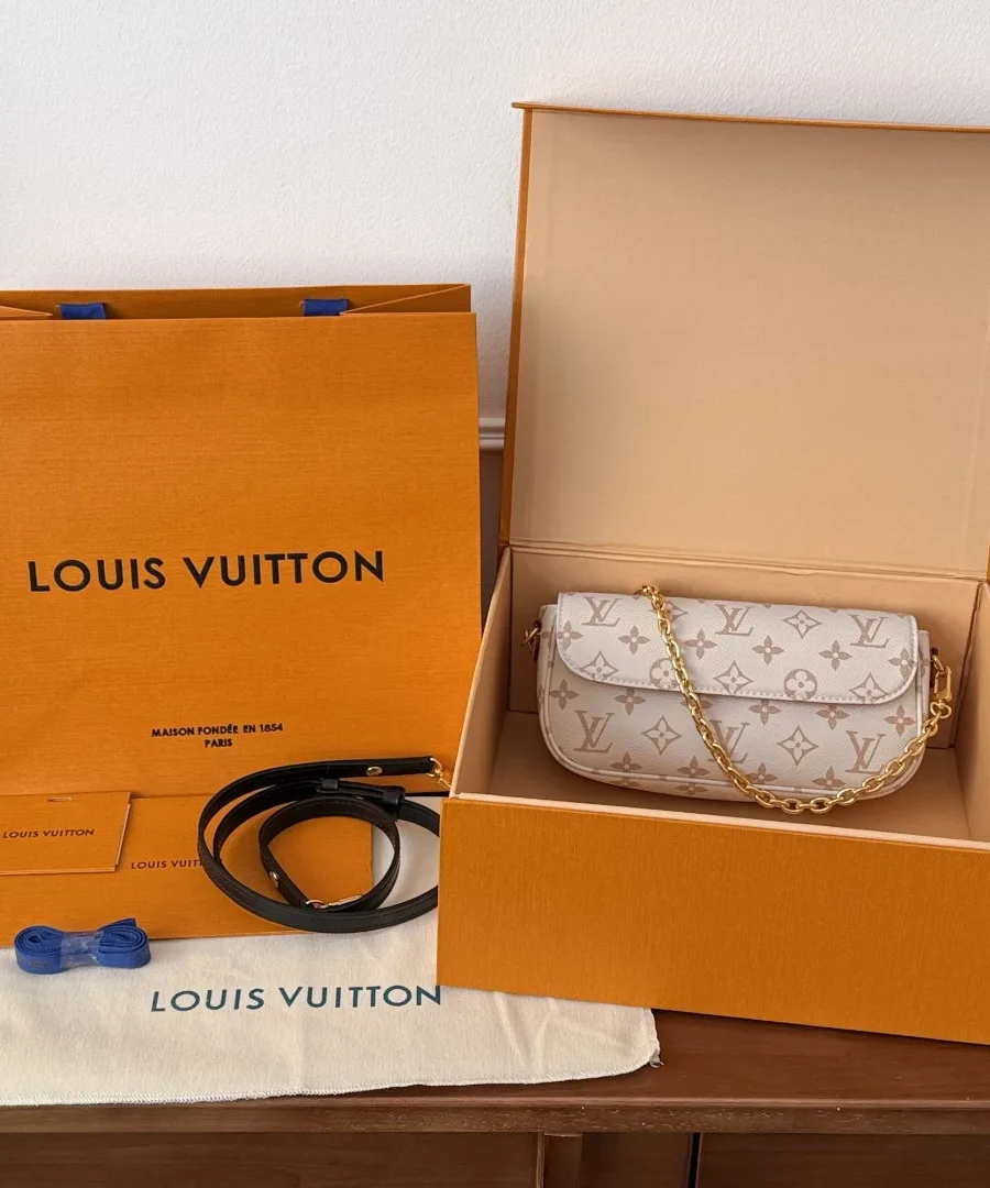 Сумка в фирменной оранжевой коробке Louis Vuitton рядом с пыльником и пакетом