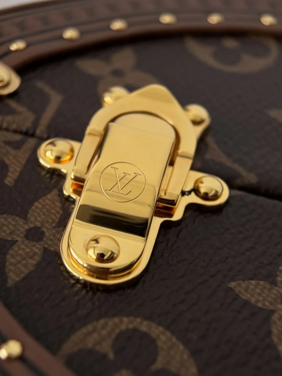 Золотистая боковая защелка на сумке Louis Vuitton Speedy Trunk