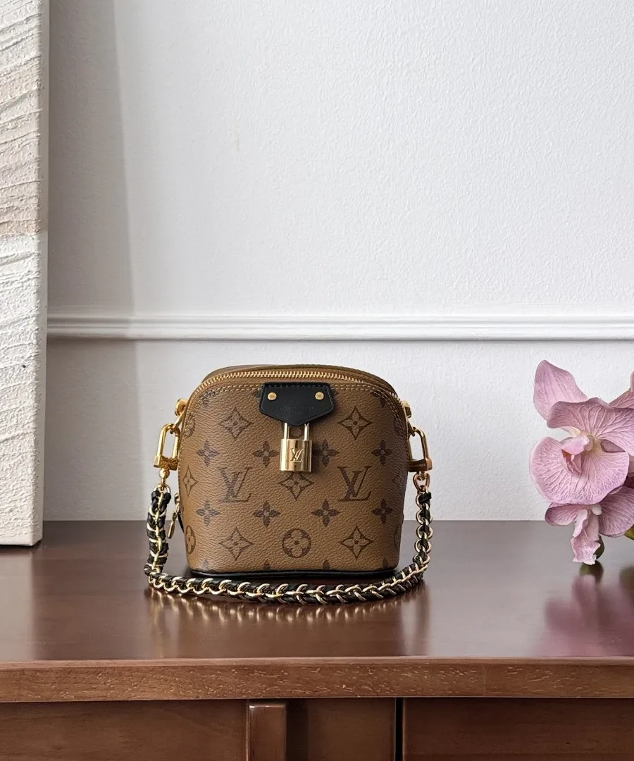 Коричневая сумка Louis Vuitton Just In Case с цепочкой на столе, вид спереди