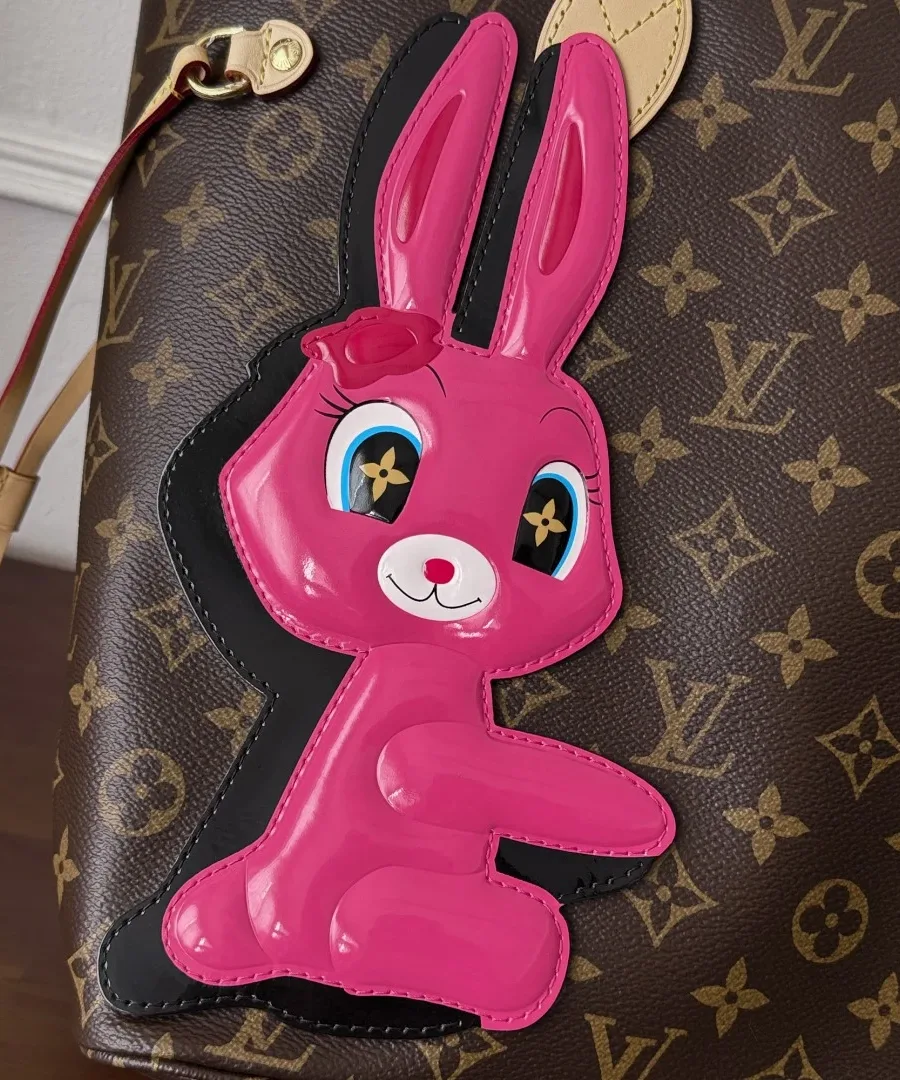 Крупный план аппликации в виде розового кролика на сумке Louis Vuitton