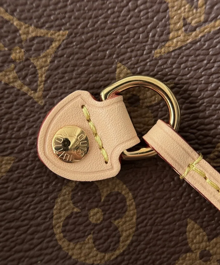 Деталь крепления ручки сумки Louis Vuitton с золотистой заклепкой