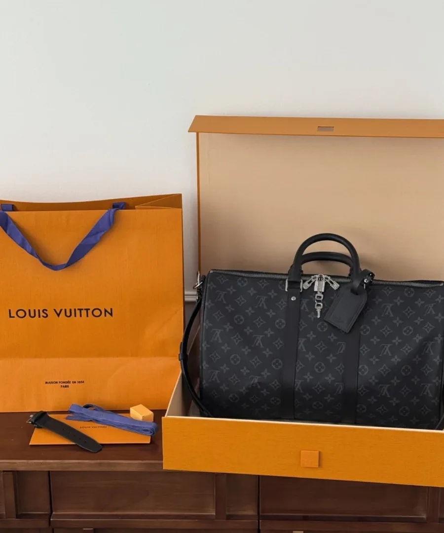 Дорожная сумка Louis Vuitton Keepall 45 в фирменной коробке рядом с оранжевым пакетом