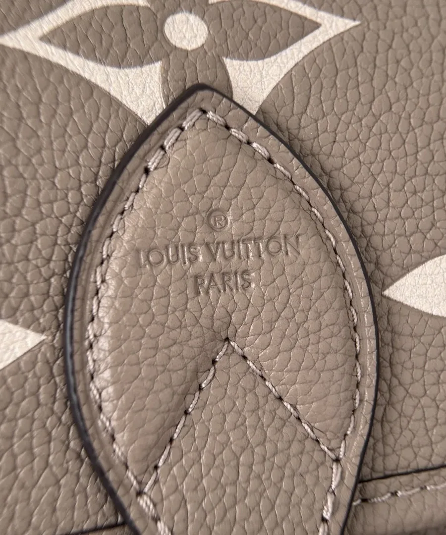 Крупный план кожаного клапана с тиснением Monogram и штампом Louis Vuitton Paris