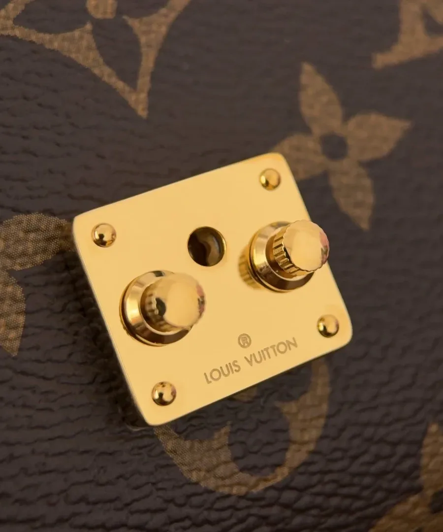 Золотистый замок S-lock с гравировкой Louis Vuitton на сумке