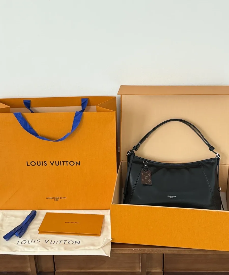 Черная сумка Louis Vuitton Carryall рядом с фирменной коробкой, пакетом и пыльником