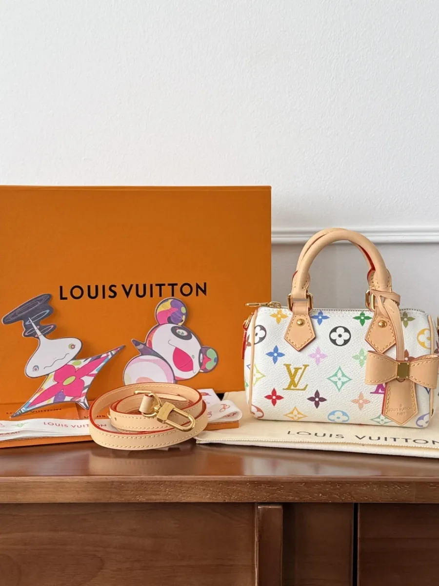 Мини-сумка Louis Vuitton Nano Speedy рядом с фирменной оранжевой коробкой и пыльником.