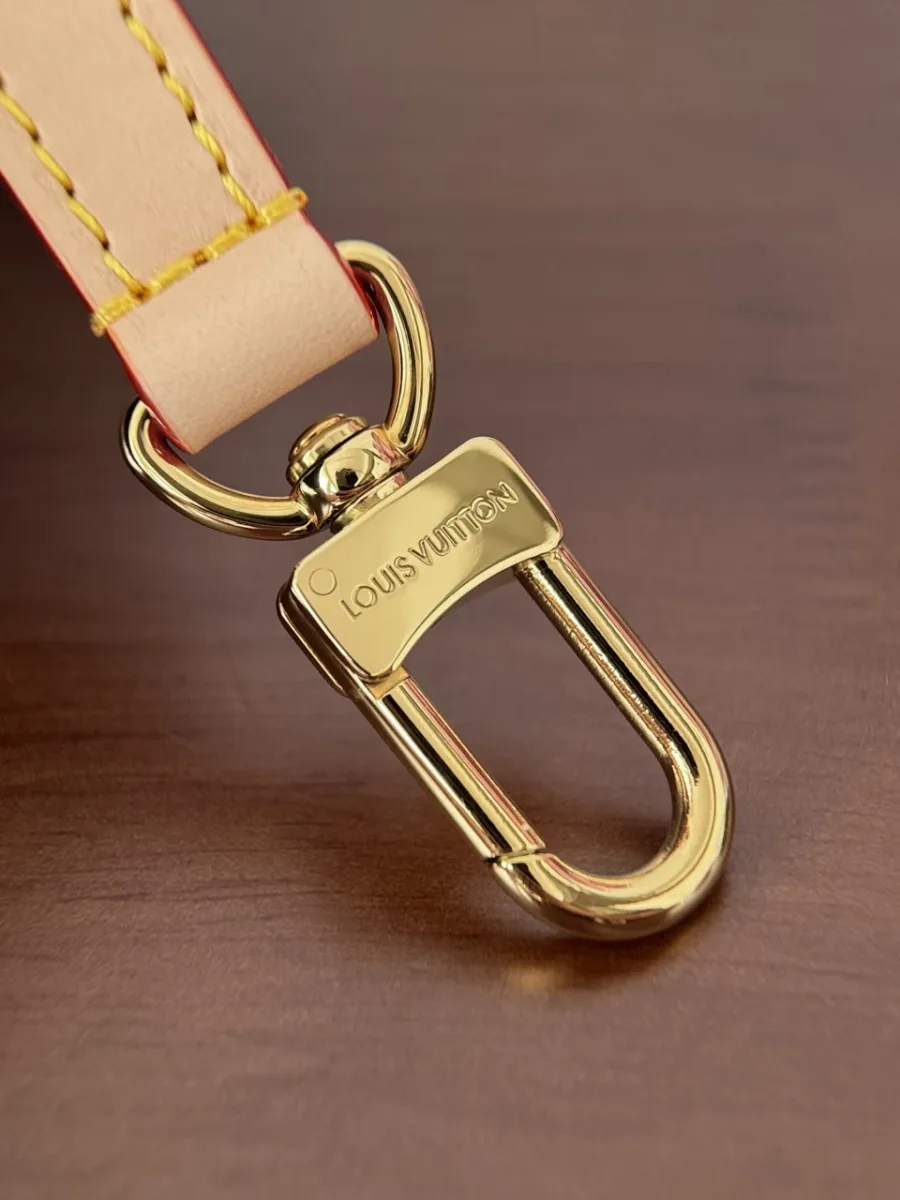 Золотистый металлический карабин плечевого ремня с гравировкой Louis Vuitton.
