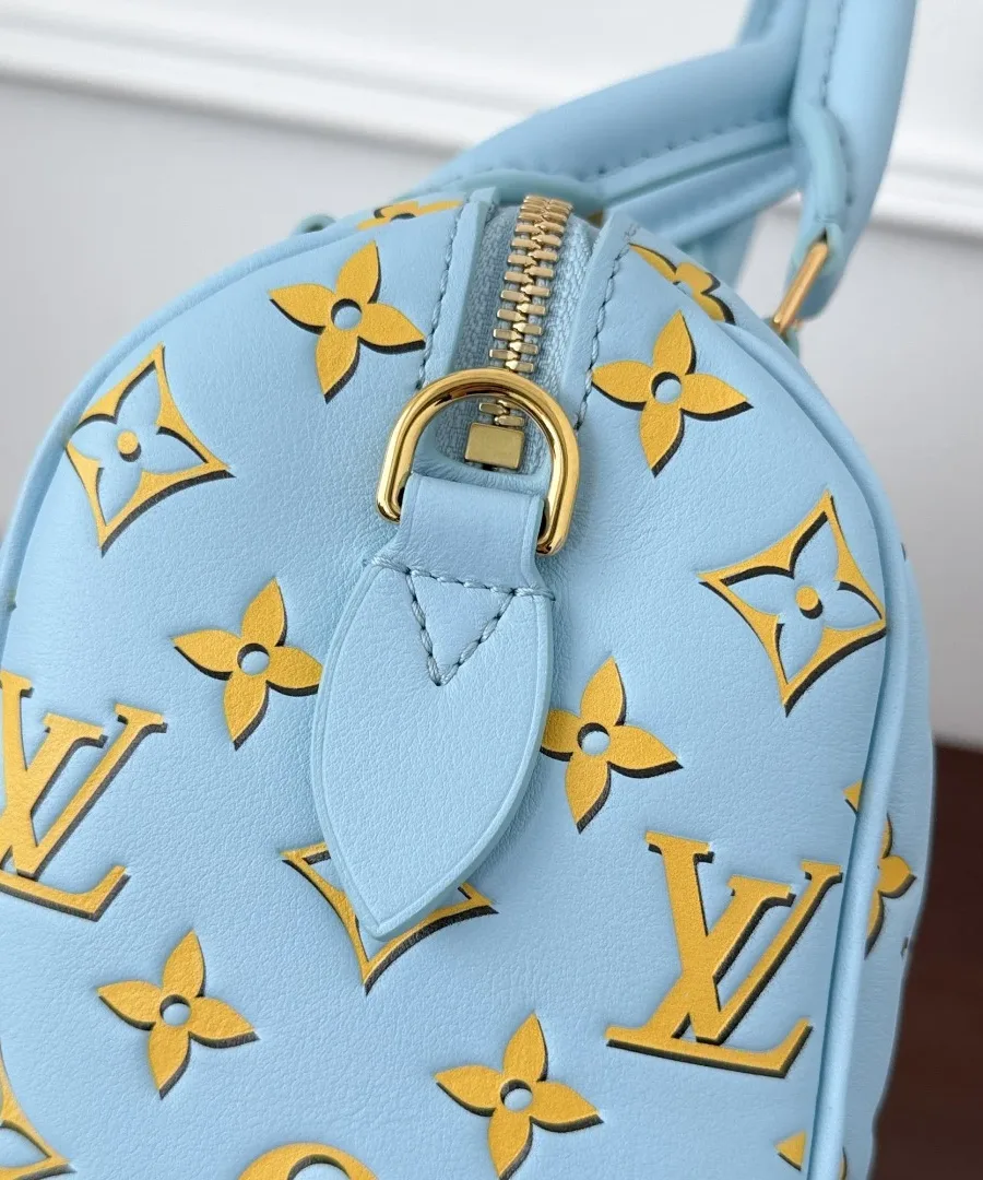 Крупный план боковой части голубой сумки Speedy 20 с золотистым креплением
