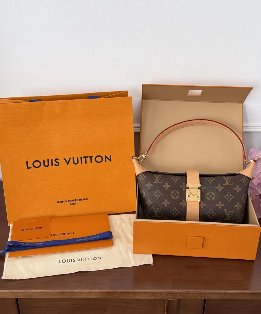 Сумка Louis Vuitton Tilsitt рядом с фирменной коробкой и пакетом