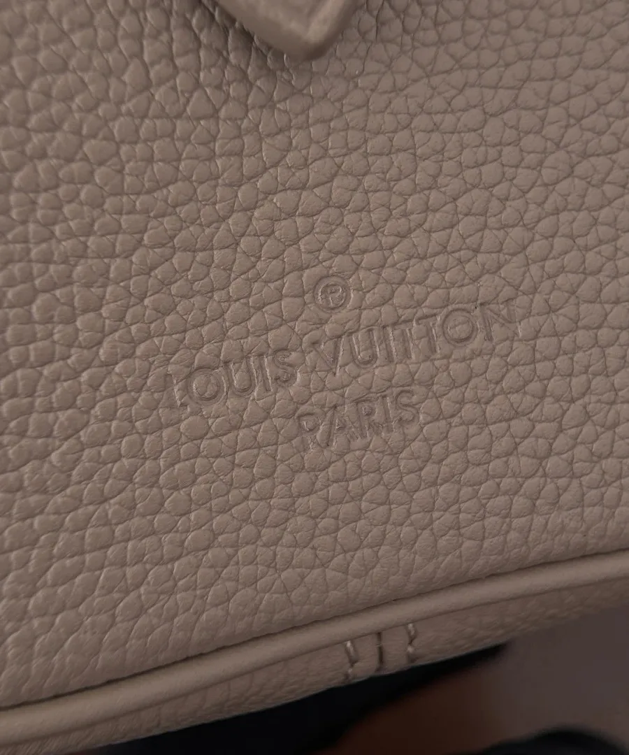 Тисненый логотип Louis Vuitton Paris на кожаной поверхности