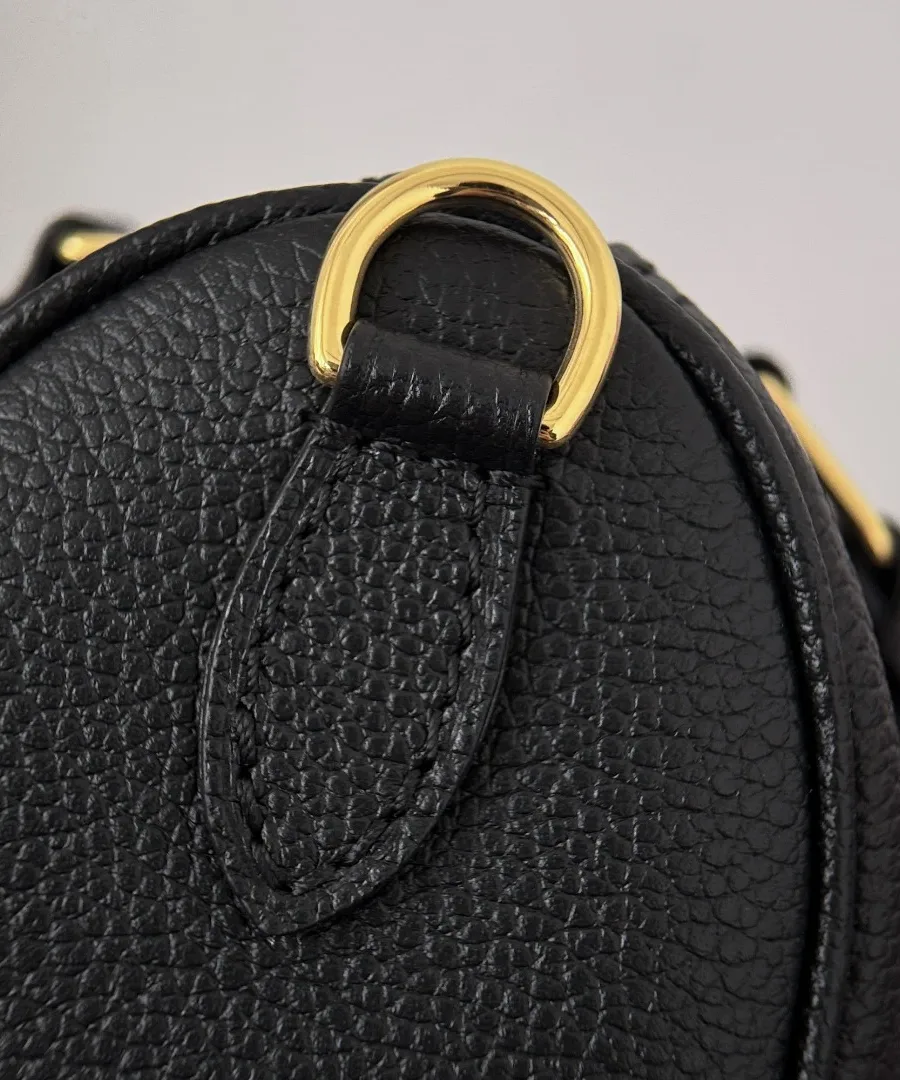 Золотистое металлическое крепление для ремня на боковой стороне сумки Louis Vuitton