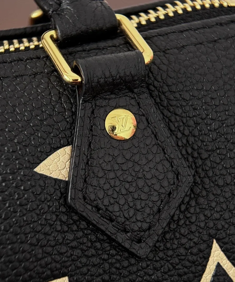 Крепление короткой кожаной ручки с золотистой заклепкой на сумке Louis Vuitton