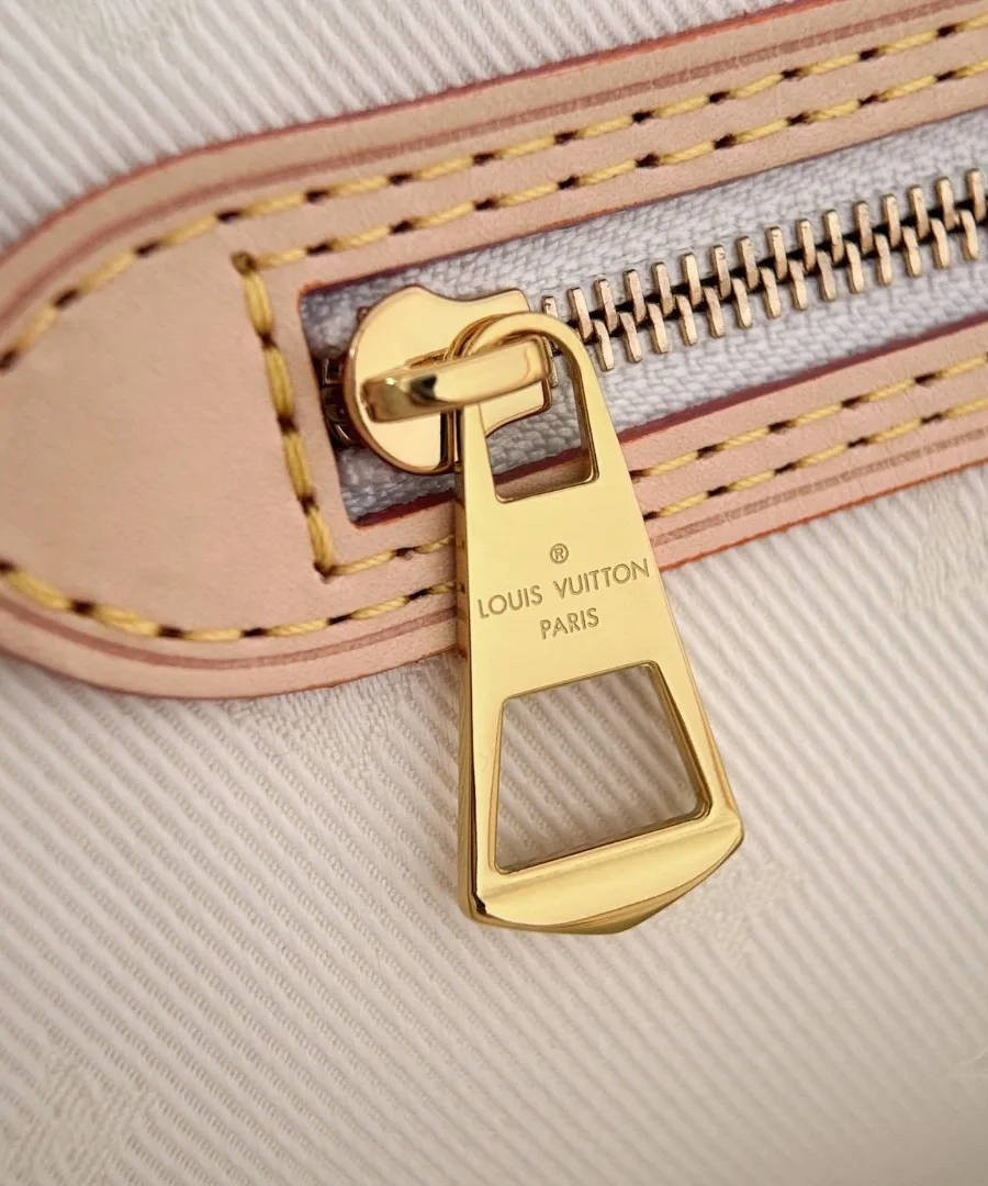 Крупный план золотистого пуллера молнии внутреннего кармана с гравировкой Louis Vuitton