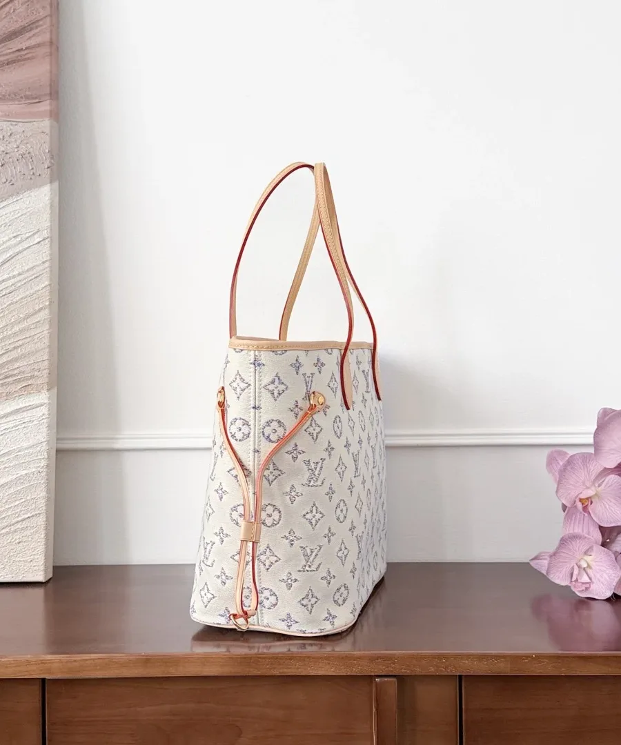 Светлая сумка-тоут Neverfull MM, вид сбоку с затянутым кожаным шнурком