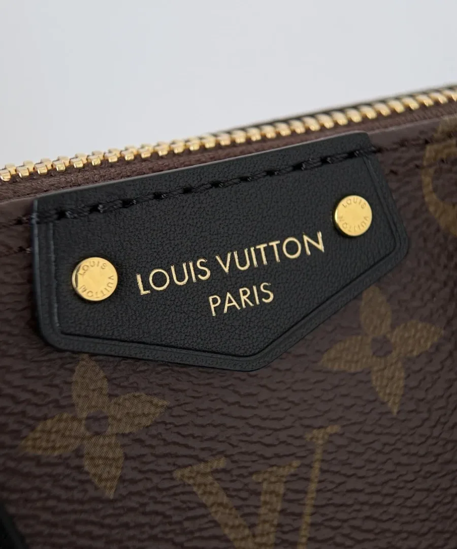 Крупный план черной кожаной нашивки с золотистым тиснением Louis Vuitton Paris