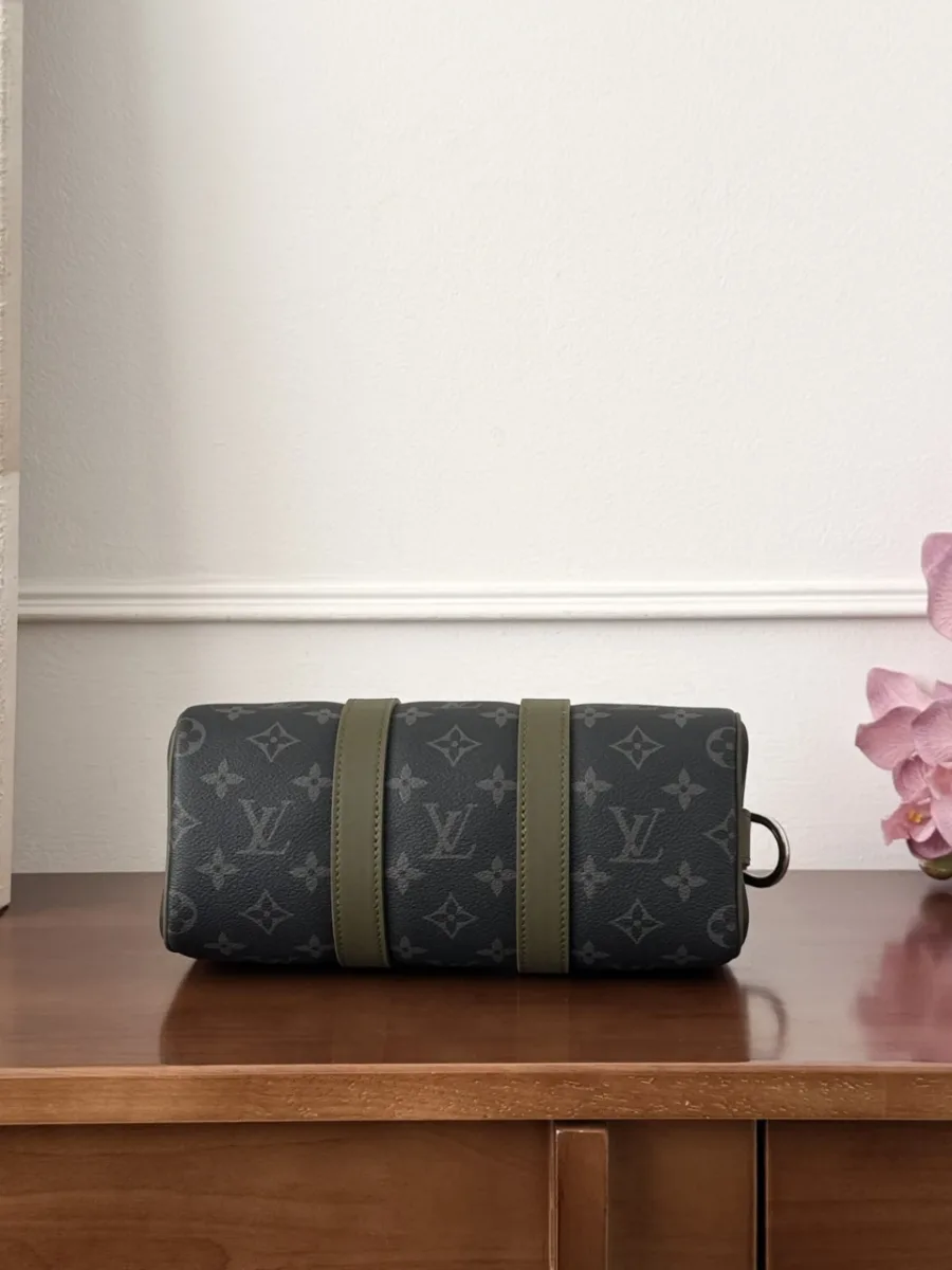 Вид снизу на сумку Keepall 25 с кожаными защитными полосами зелёного цвета