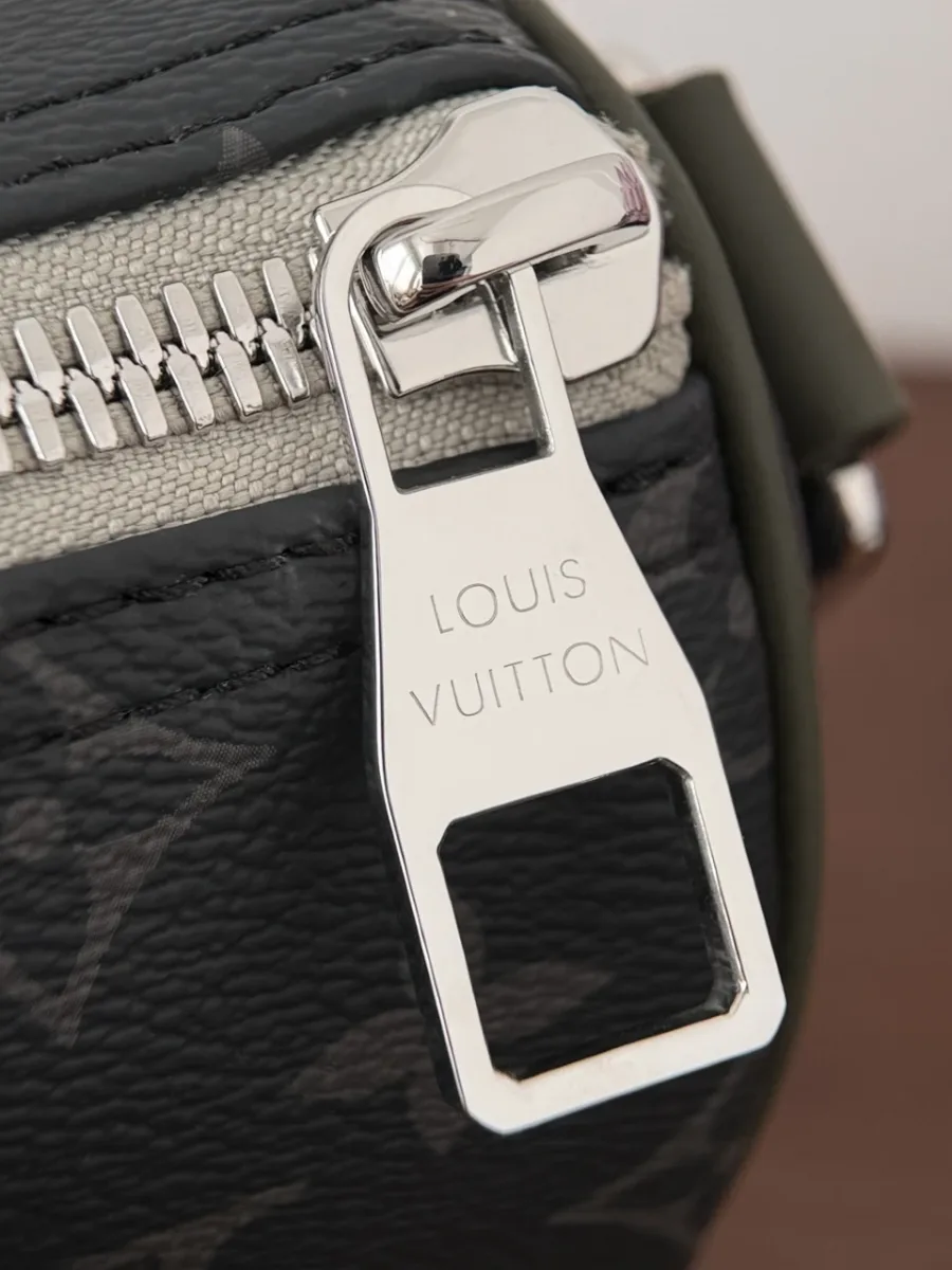Крупный план серебристой молнии и пуллера с гравировкой Louis Vuitton